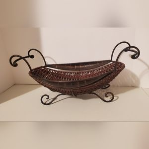 Vintage brown wicker and metal sleigh basket with metal handles and feet